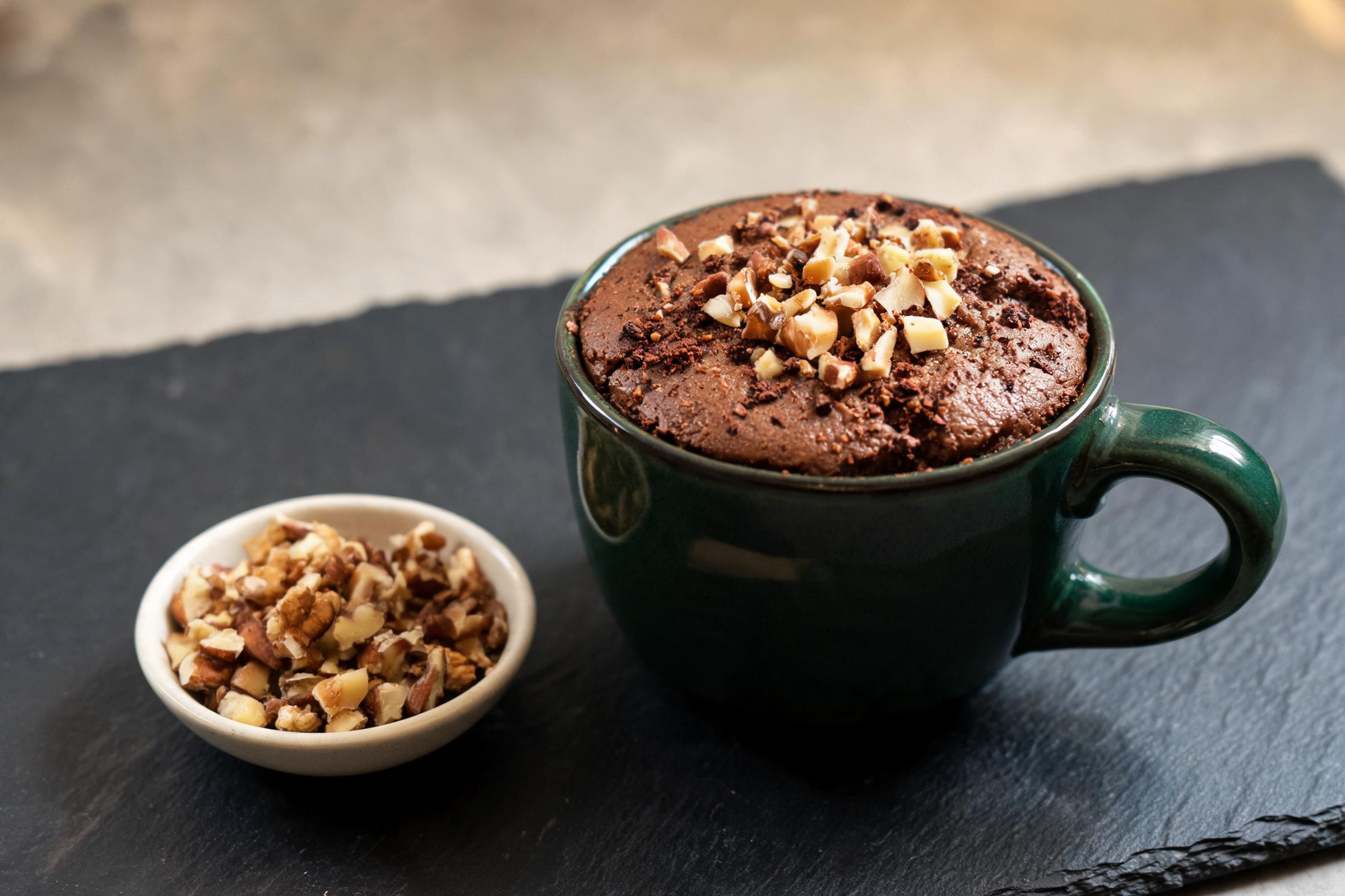 Gluten-free cocoa nut mug cake topped with chopped walnuts