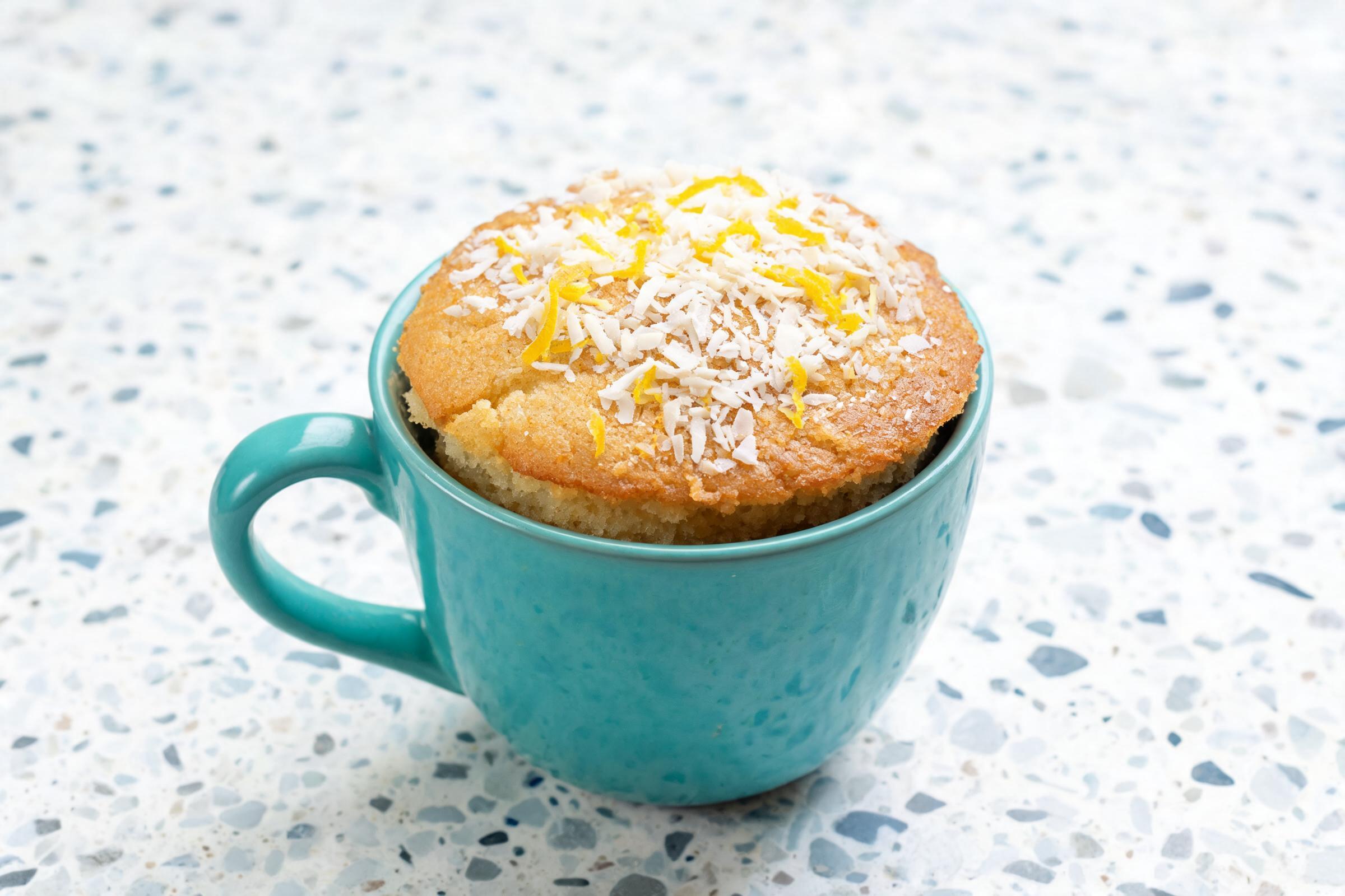 Vegan lemon coconut mug cake topped with shredded coconut